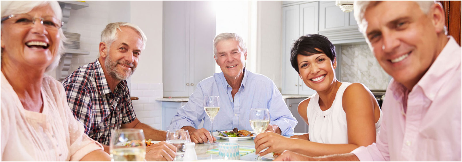 family eating dinner sitting around a table and smiling at camera - Clearfield Medical Reno NV