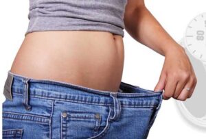 woman with oversized pants after weight loss right angle - Dr. Clearfield Reno NV
